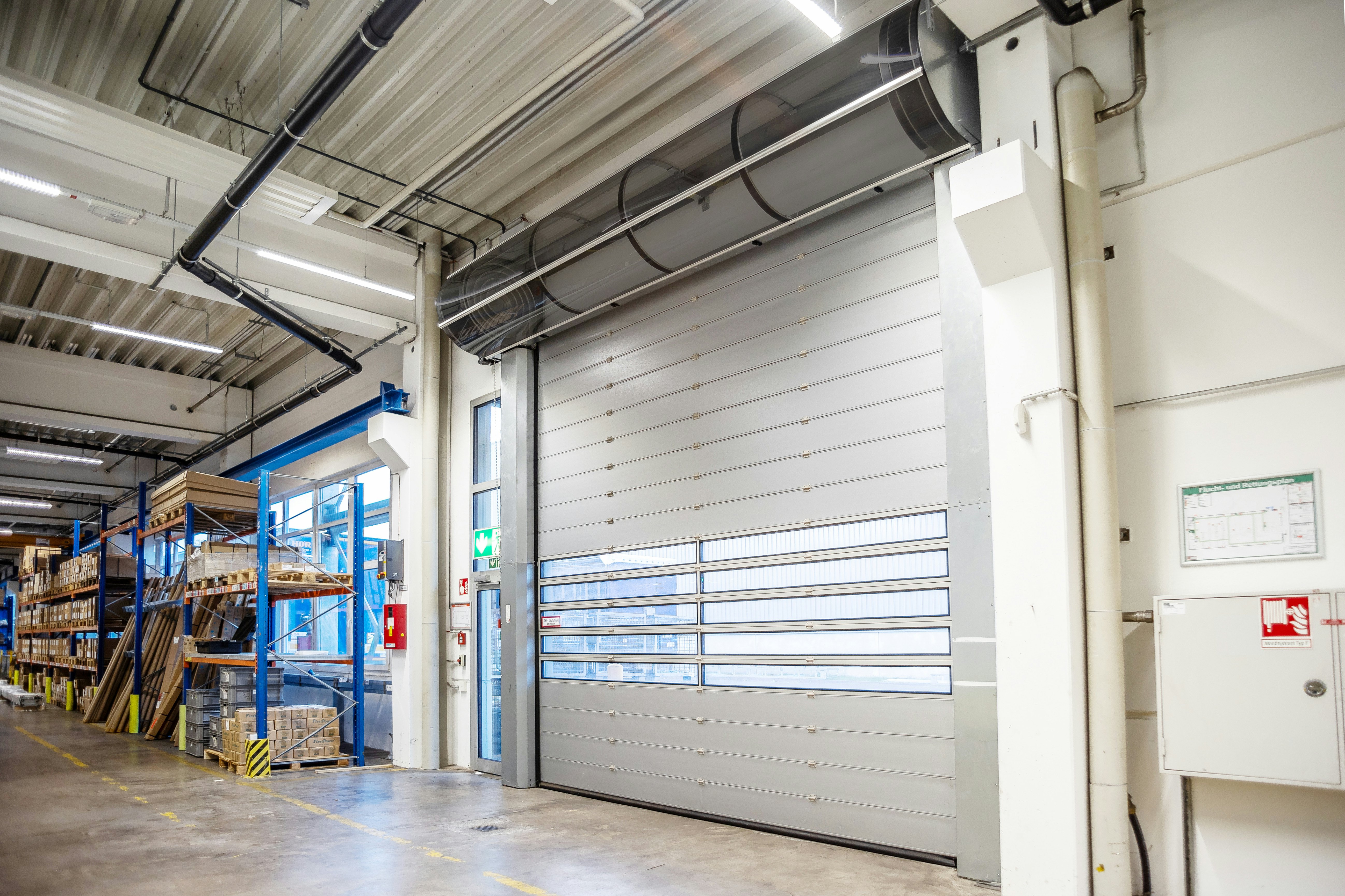 Besonders leicht und deshalb besonders wartungsfreundlich: Wellen- und Antriebsverkleidung aus Polycarbonat Industriehalle mit Spiraltor und Wellenverkleidung
