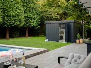 Gute Gründe für Hörmann Stauraumsysteme: Garten mit Terrasse, Pool und grauem Gerätehaus