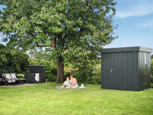 Your home is where you create the most cherished memories... Mother and child sitting on a blanket in front of the shed in the garden