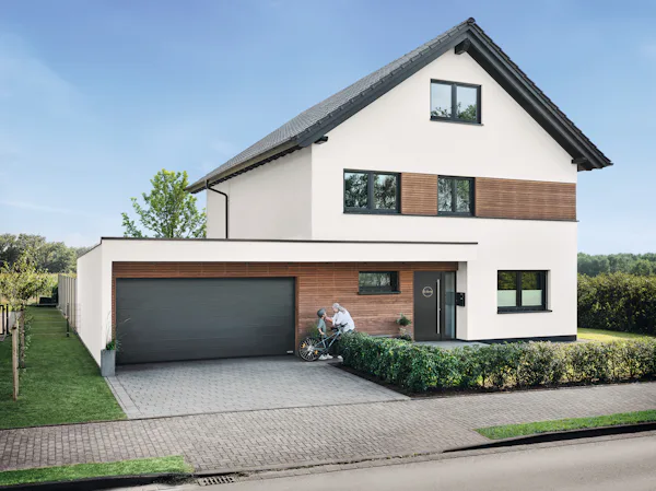 RenoMatic Sectionaaldeur | Hörmann Vrijstaand huis witgeverfd met houtaccenten en een Hörmann sectionale garagedeur