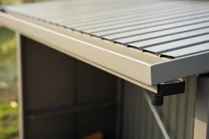 Detailfoto dak houtopslag | Hörmann Een ingezoomde foto van een groengekleurde houtopslag van Hörmann. Op de foto is ingezoomd op de hoek van het dak van de houtopslag.