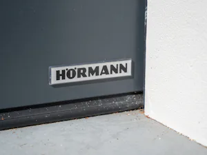 Veiligheidsopties Detailfoto logo sectionaaldeur met loopdeur van Hörmann