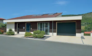 Kenmerken die roldeuren praktisch en Moderne bungalow met zwarte Hörmann roldeur, houten gevelaccenten en zonnepanelen op het dak.