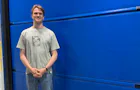 Marijn, medewerker Marketing, voor een blauwe Hörmann deur.