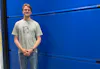 Marijn, medewerker Marketing, voor een blauwe Hörmann deur.