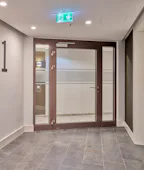 Hörmann Tür mit zwei gläsernen Seitenteilen. Viel Licht, weite Ausblicke – in einem Wohnhochhaus wie dem Grand Tower in Frankfurt sind es diese Argumente, die hohe Quadratmeterpreise rechtfertigen sollen. Entsprechend viel Glas ist in der...