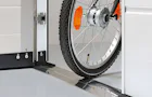 Praktiska lösningar Närbild på den låga tröskeln vid passage genom en dörr i porten. En cykel rullar enkelt över.