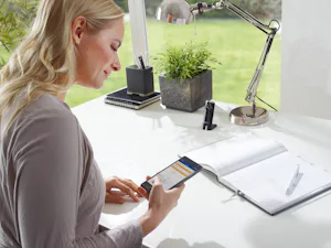 Innovative Technik plus exklusives Design: Mit dem passenden... Frau bedient Tore und Türen bequem mit dem Smartphone vom Schreibtisch aus