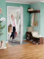 Accessoires voor binnendeuren Een vrouw loopt met haar boodschappentassen door een binnendeur die automatisch opent.