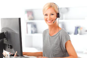Preventief Een vrouw zit achter haar computer en heeft een headset op haar hoofd.