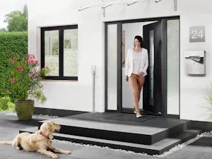 Thermo65 Vrouw loopt moderne voordeur uit | Hörmann