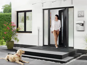 Thermo65 Vrouw loopt moderne voordeur uit | Hörmann