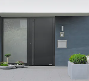 Extra opties voor uw Strakke gevel met Hörmann ThermoPlan Hybrid voordeur, zijlicht en grijze tegels, omringd door moderne plantenbakken.
