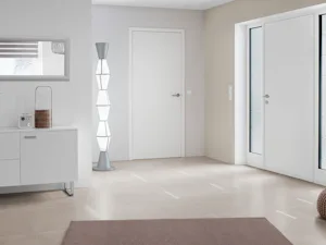 Top design aan binnen- Witte Hörmann ThermoPlan Hybrid voordeur met zijlichten in moderne hal met beige muur en minimalistisch interieur.