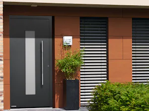 Ihre Vorteile im Überblick:
Hightech-Flügelprofil aus... Haus mit rostfarbener Fassade und grauer ThermoCarbon Haustür