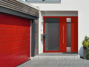 Für noch mehr Freude am eigenen Zuhause lassen sich... Rote ThermoSafe Haustür mit großem verglastem Seitenfenster und ansichtsgleichem Garagentor