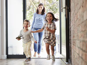 Für noch mehr Freude am eigenen Zuhause lassen sich... Junge Familie mit zwei Kindern betritt ihr Haus