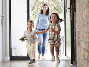 Für noch mehr Freude am eigenen Zuhause lassen sich... Junge Familie mit zwei Kindern betritt ihr Haus