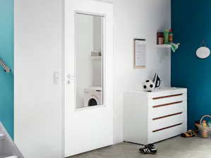 ZK functionele binnendeur | Hörmann Witte functionele binnendeur ZK van Hörmann in een woonhuis. Rechts op de foto ziet u een witte kast met lades en door de foto heen kunt u rondzwervend speelgoed zien.