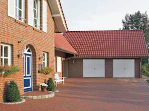 Bij een 2-vleugelige openslaande garagepoort kunnen naar... Voorkant van het huis met twee garagedraaivleugeldeuren
