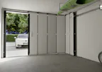 Elektrische garagedeur met loopdeur | Hörmann Een auto wacht voor een garage tot deze geopend is. De garagedeur is een zijdelingse sectionaaldeur van Hörmann.
