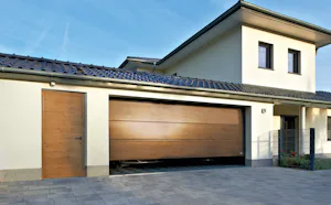 Garážová sekční vrata v barvě Decograin Winchester Oak se vzhledově stejnými vedlejšími dveřmi