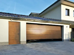 Szekcionált garázskapu, L-bordás Decograin Winchester Oak ugyanolyan kinézetű mellékajtóval