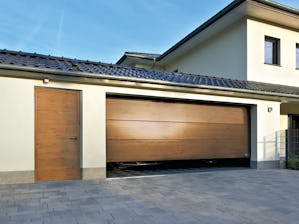 Garagesectionaaldeur, L-profilering in Decograin Winchester Oak met zijdeur met hetzelfde aanzicht Garagesectionaaldeur, L-profilering in Decograin Winchester Oak met zijdeur met hetzelfde aanzicht
