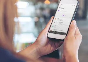 Garagedeur sectionaal Persoon bediend mobiele telefoon zoekende naar de Smart Home opties van Hörmann.