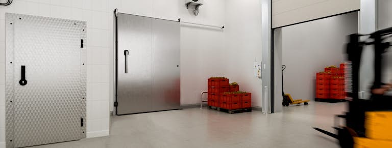 Isolatiedeuren van Hörmann in gebruik, heftruck rijdt af op een geopende vouwdeur van Hörmann.