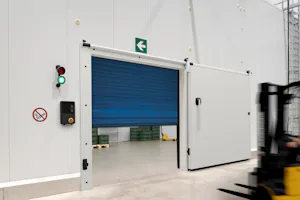 Een combinatie van isolatiedeuren en pendeldeuren of... vouwdeur F 4010 Cold high-speed van Hörmann gaat snel open zodat forklifttruck erdoorheen kan