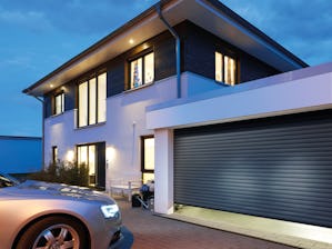 Les portes de garage enroulables RollMatic s’ouvrent à la... Les portes de garage enroulables RollMatic s’ouvrent à la verticale et ne nécessitent qu’une place minime dans le garage. Grâce à leur principe de construction, elles offrent un espace de...