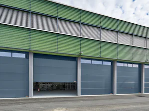 Portoni con elementi in acciaio a doppia parete L'uso di portoni sezionali industriali ben coibentati e duraturi è particolarmente consigliato per capannoni riscaldati e per il duro lavoro quotidiano nell' industria, nel commercio e...