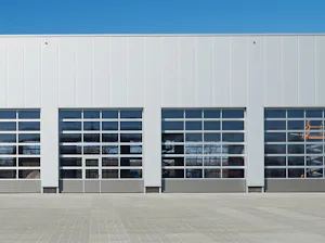 Portes vitrées en aluminium avec section basse en acier à rainures Portes sectionnelles industrielles APU Hörmann.