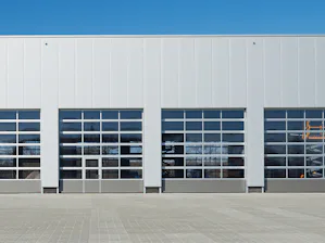 Portes vitrées en aluminium avec section basse en acier à rainures Portes sectionnelles industrielles APU Hörmann.