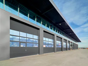 De grandes baies extérieures de bâtiments à usage industriel... De grandes baies extérieures de bâtiments à usage industriel sont fréquemment fermées avec des portes sectionnelles industrielles. Ces portes sont notamment installées dans des centres logistiques,...