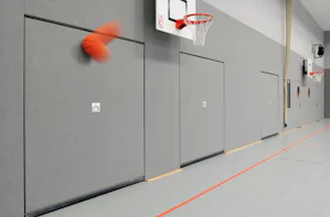 Les portes pour halls omnisports servent de séparation entre... Les portes pour halls omnisports servent de séparation entre la surface praticable et les locaux du matériel sportif. La porte pour hall omnisports Hörmann satisfait aux prescriptions de prévention...