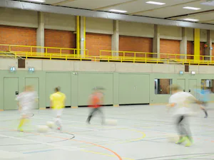 Vrata za športne dvorane Hörmann so zasnovana v skladu z... Vrata za športne dvorane Hörmann so zasnovana v skladu z veljavnimi varnostnimi standardi za uporabo v šolskih in športnih objektih. Vratno krilo je preizkušeno glede odpornosti proti udarcem žoge po...