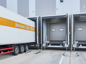 Enkel- of dubbelwandig? Met bouwkundige beplating, of... Buitenaanzicht met aangedockte vrachtwagen met voorzetsluizen van Hörmann
