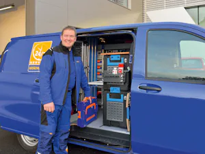Montáž a údržba Servisní technik stojí před autem