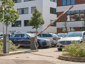Onze parkeergarage- en parkeerplaatssystemen voor betaald... Auto rijdt door geopende Hörmann slagboom