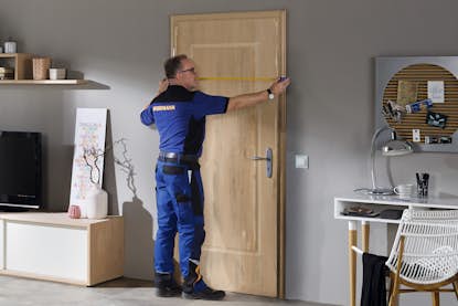 Fachmann nimmt das Türmass einer Zimmertür. Fachmann nimmt das Türmass einer Zimmertür.