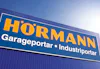 Blå fasad med Hörmann-skylt.