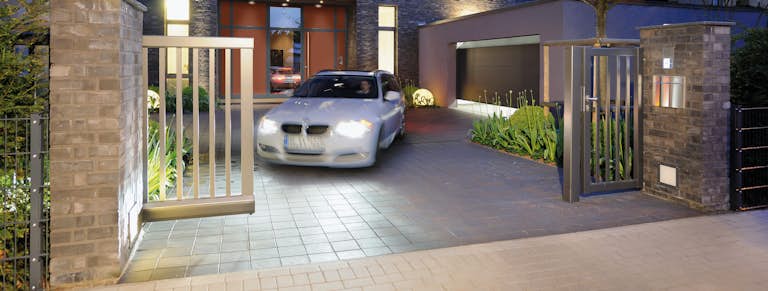 Bil för ut från uppfarten genom en infartsgrind.