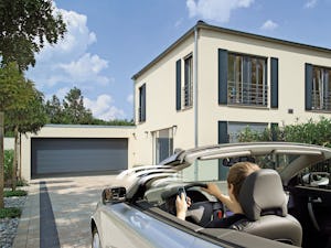 Våra garageportsmotorer låter dig köra in i garaget, skyddad... Man sitter i sin bil på uppfarten och öppnar garageporten med en fjärrkontroll.