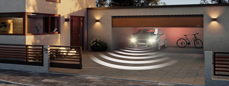 Porten öppnar sig och en bil kan köra ut från garaget.