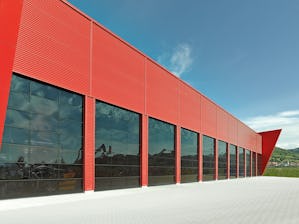 Industritakskjutportar Röd fasad med helglasade mörka portar.