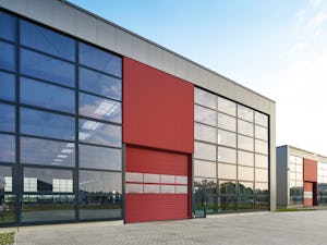 Hörmann industritakskjutportar är resultatet av generationer... Industrifastighet med matchande röd port.