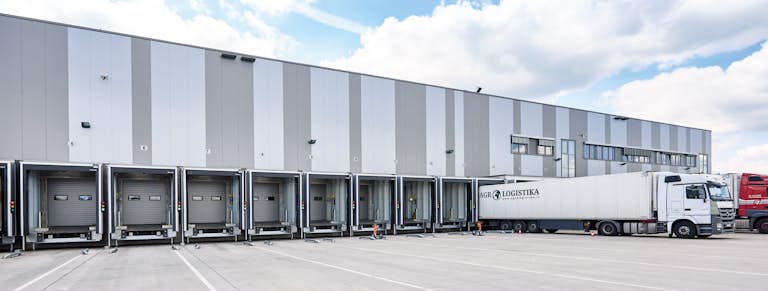 Latsbil står dockad i ett lasthus längs en fastighet.