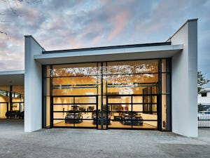 Industritakskjutportar Helglasad fasad och port vid en bilhall.